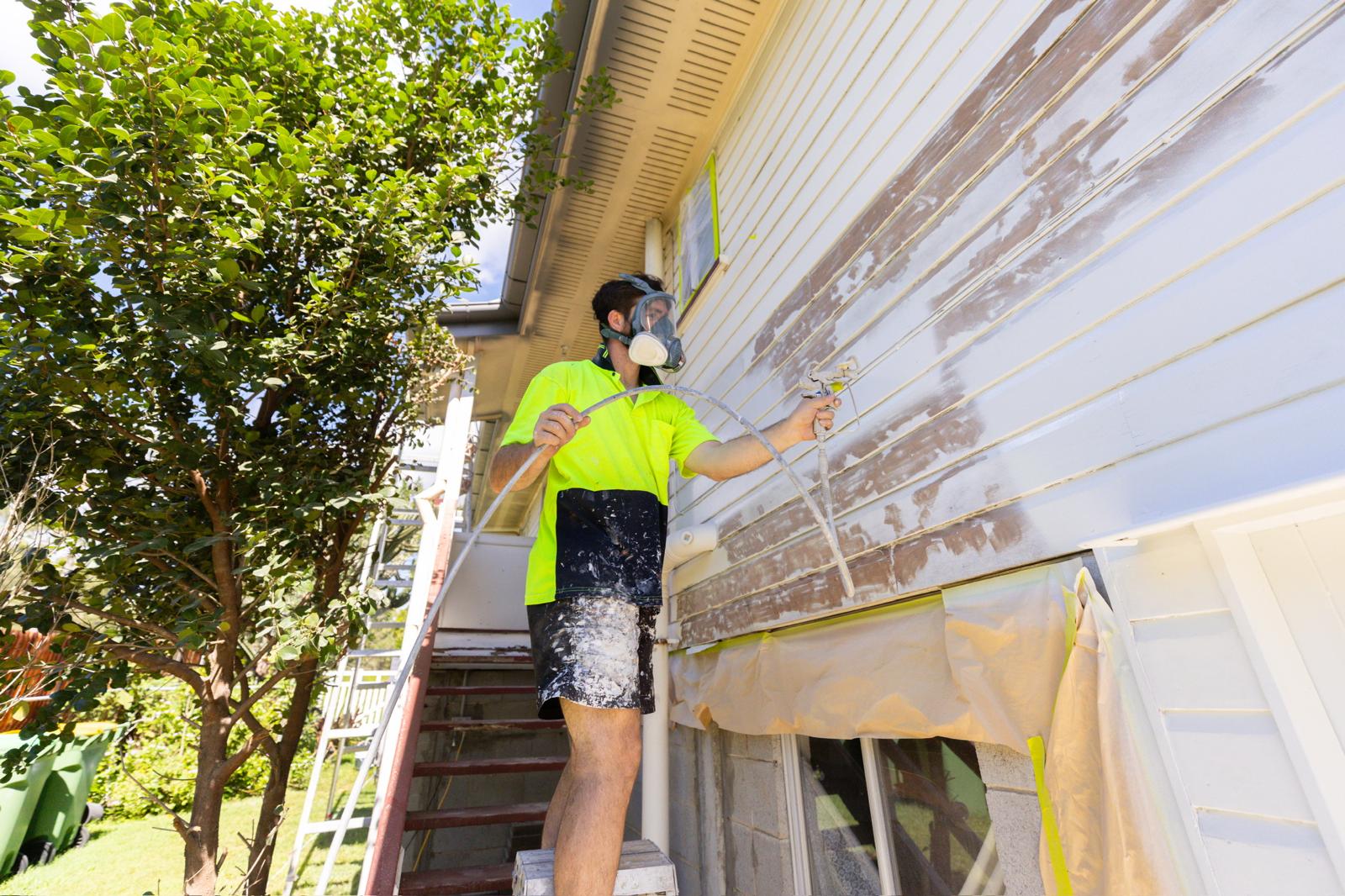 Exterior spray painting Queensland weatherboard home with professional airless equipment